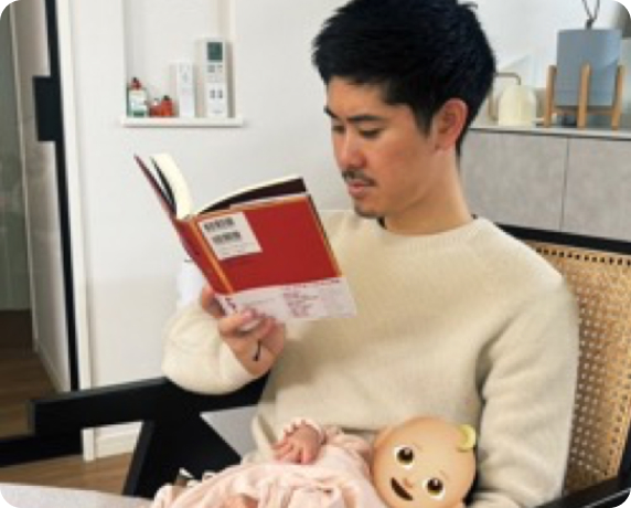 子どもを抱きながら、趣味の読書を楽しむほったさん。穏やかで、幸せなひととき